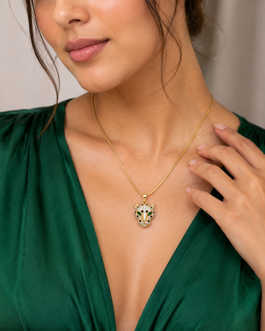 Woman in a green V-neck outfit wearing a NAXAYA gold-tone panther pendant necklace with green eyes.
