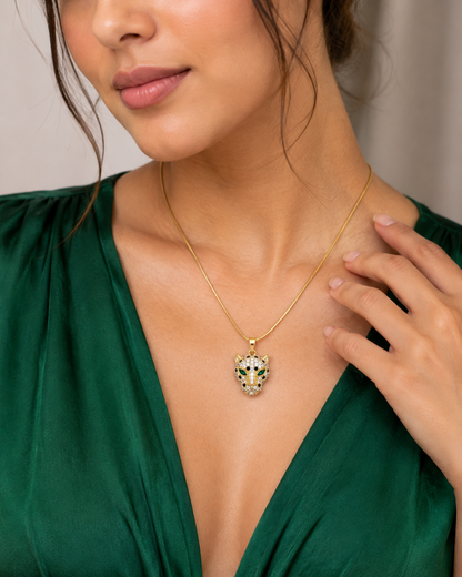 Woman in a green V-neck outfit wearing a NAXAYA gold-tone panther pendant necklace with green eyes.