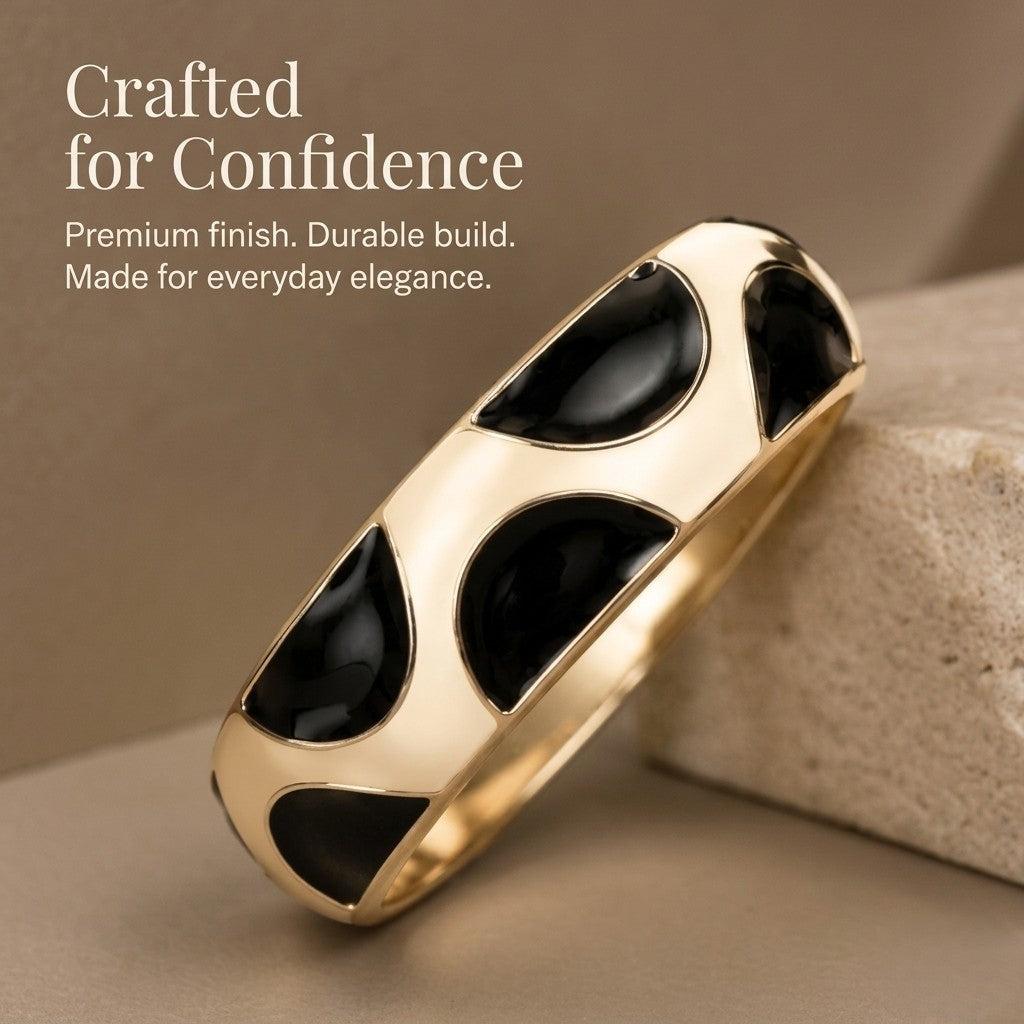 NAXAYA Modern Noir kada bracelet leaning against beige stone, showing glossy black half-moon enamel and a gold-tone finish.
