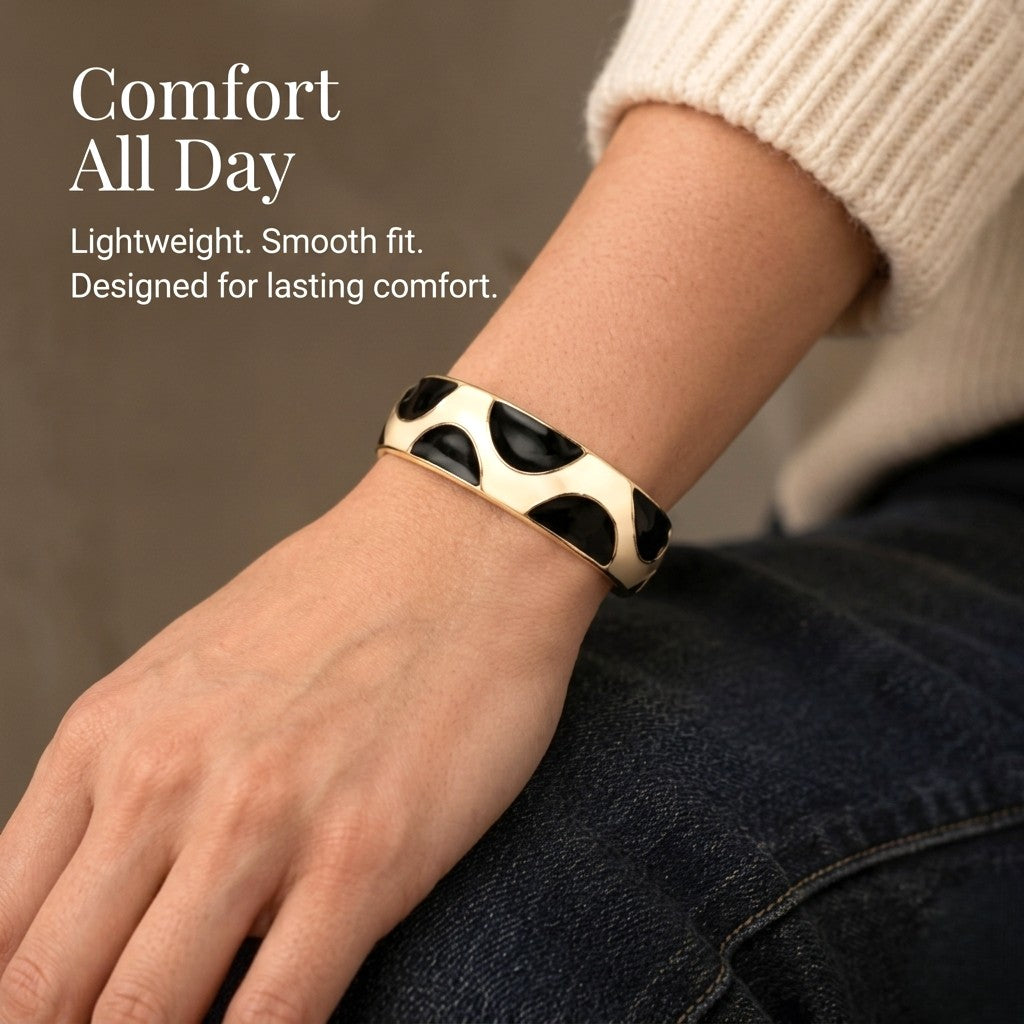 NAXAYA Modern Noir black enamel and gold-tone kada bracelet worn with a cream sweater, with the caption Comfort All Day.