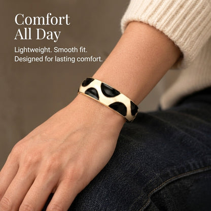 NAXAYA Modern Noir black enamel and gold-tone kada bracelet worn with a cream sweater, with the caption Comfort All Day.
