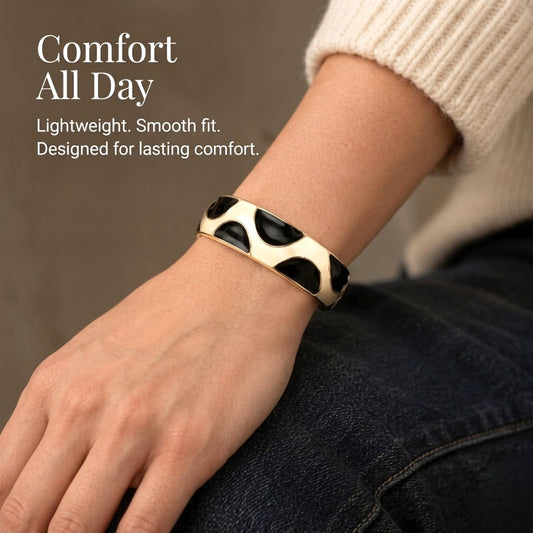 NAXAYA Modern Noir black enamel and gold-tone kada bracelet worn with a cream sweater, with the caption Comfort All Day.