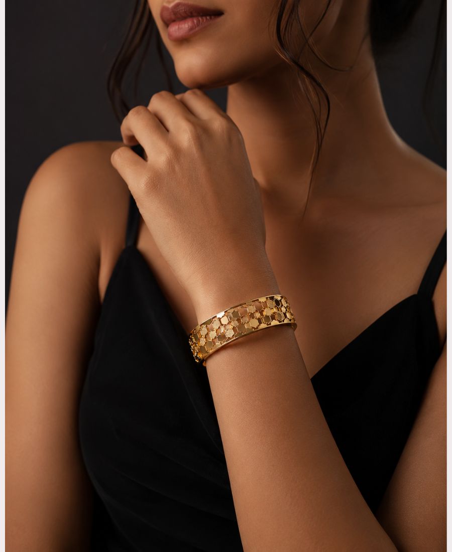 Woman wearing NAXAYA Hexovra gold bracelet with elegant black western dress