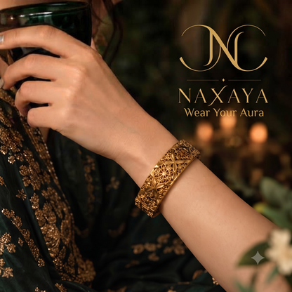  Close-up of Naxaya traditional gold filigree cuff bracelet worn on a wrist.