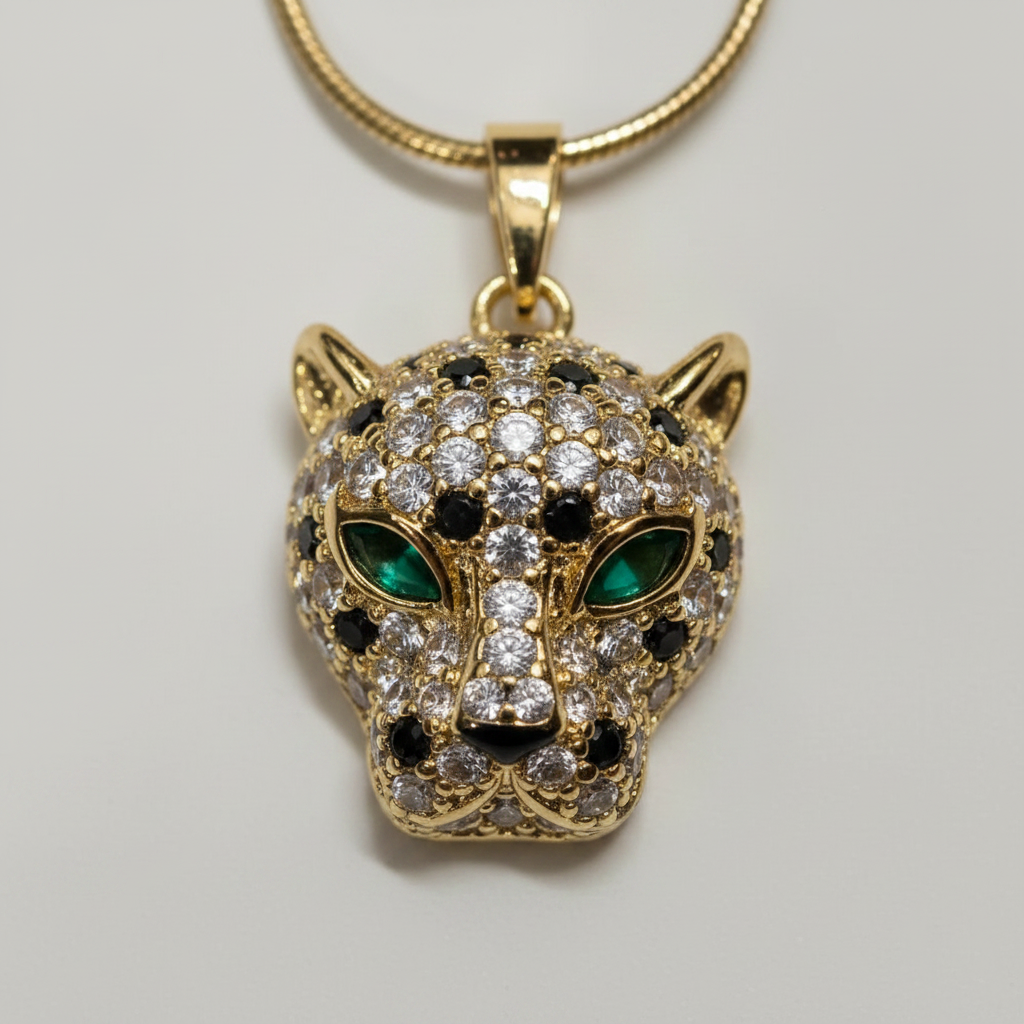 Close-up of NAXAYA gold-tone panther pendant showing green eyes, clear stones and black spotted detailing.