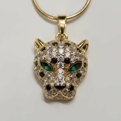 Close-up of NAXAYA gold-tone panther pendant showing green eyes, clear stones and black spotted detailing.