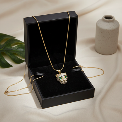 NAXAYA gold-tone panther pendant necklace with green eyes displayed in an open black jewellery box.